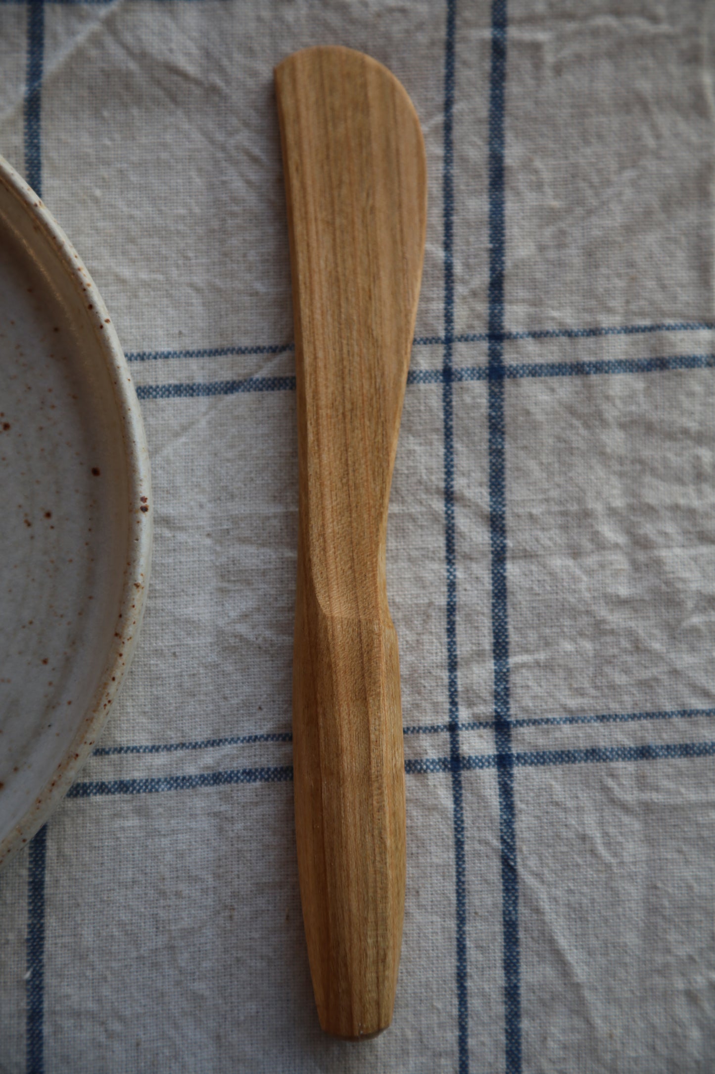 Front on view of a handcarved cherrywood butter knife 