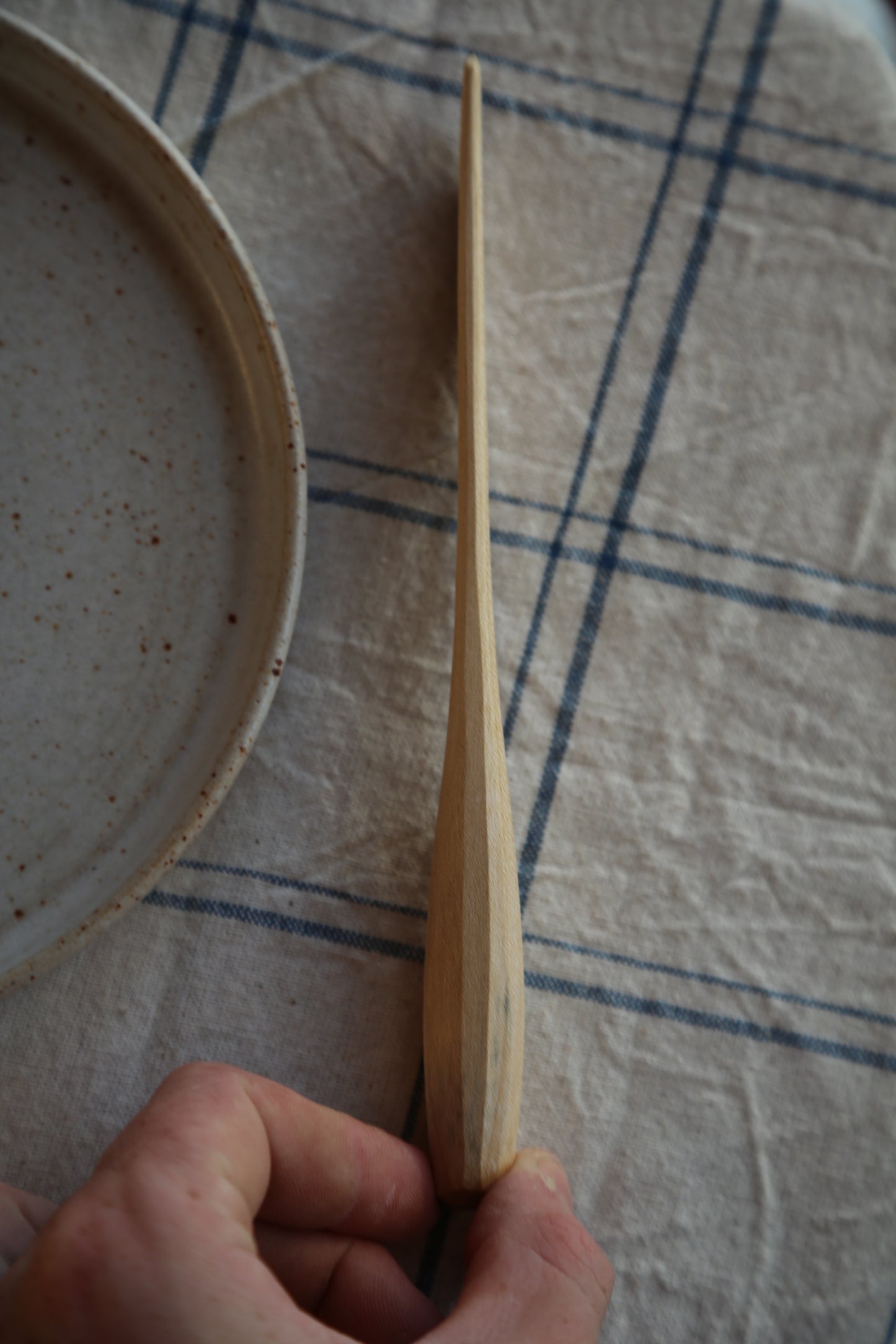 Side profile of a handcarved sycamore butter spreader 