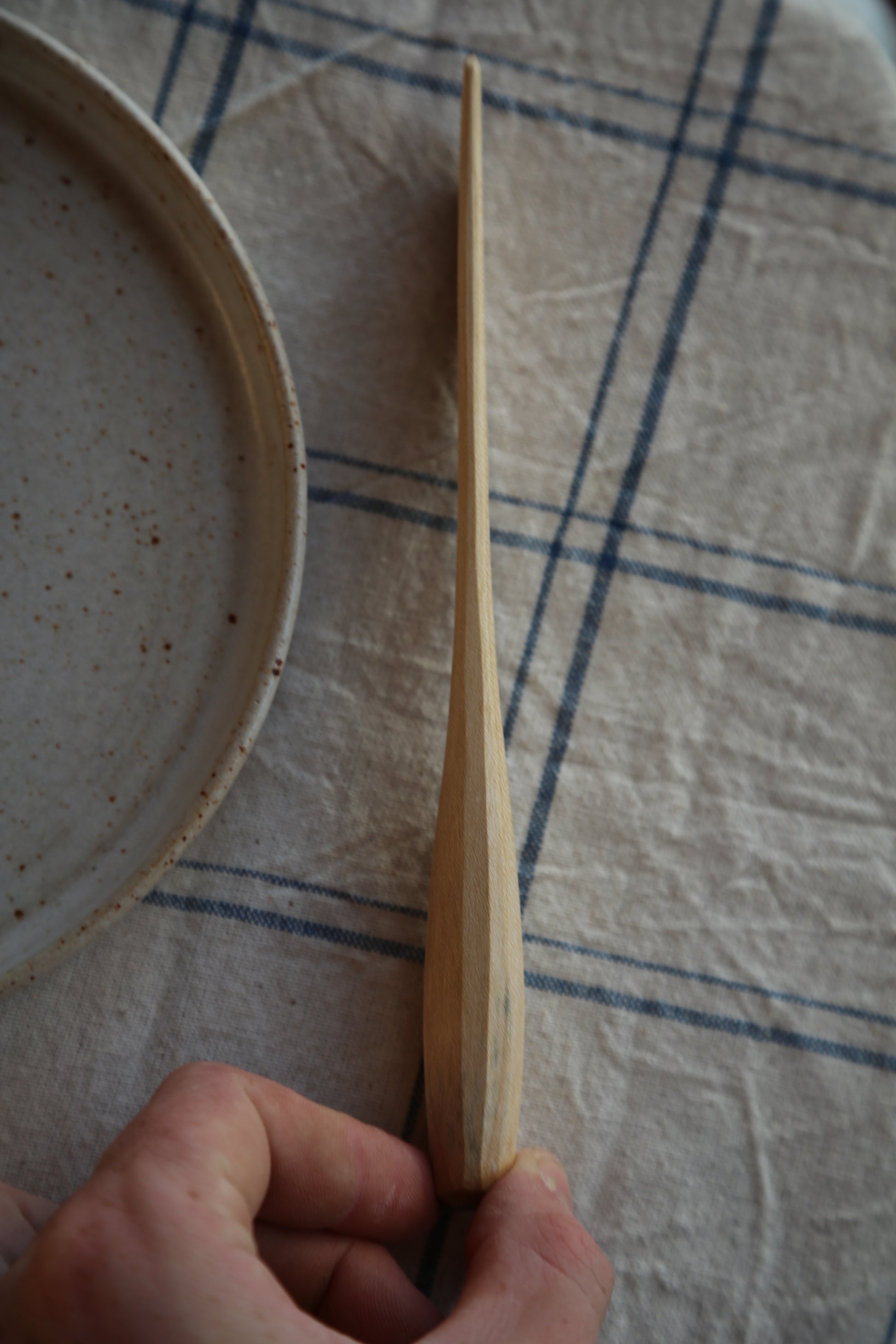 Side profile of a handcarved sycamore butter spreader 